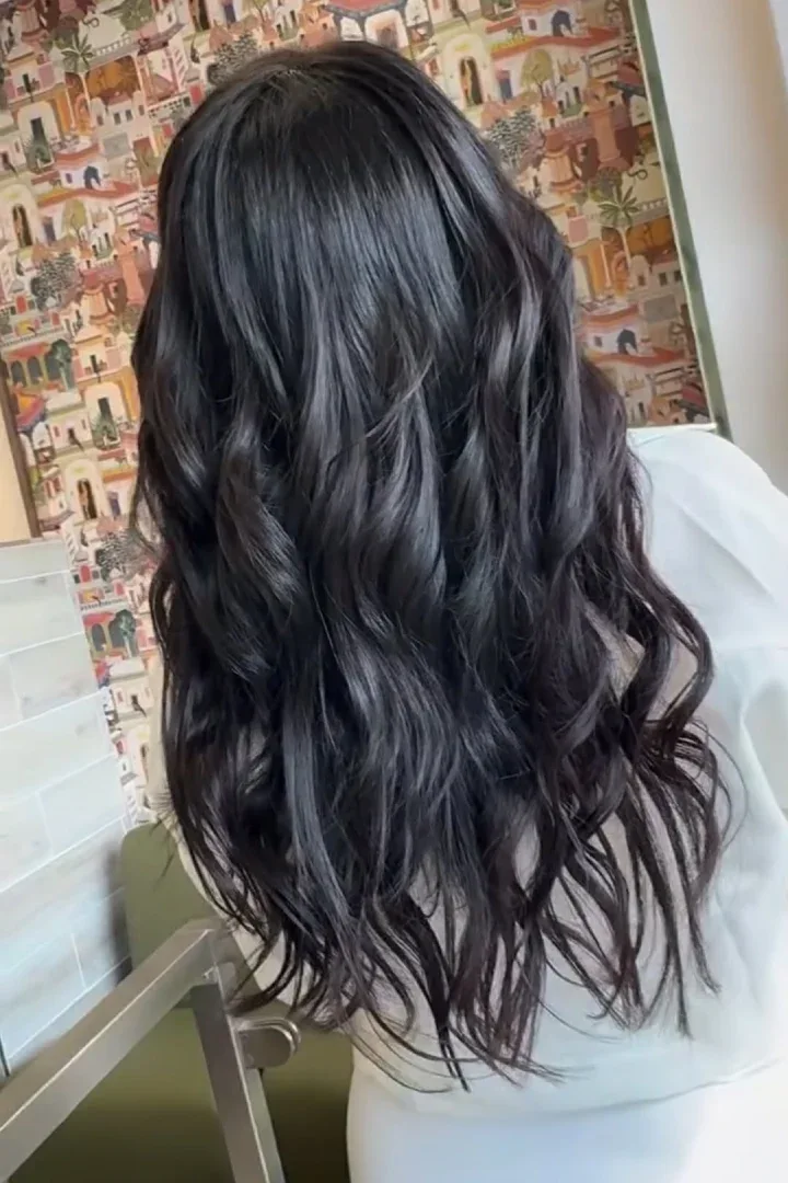 a woman's dark curly hair at a hair salon