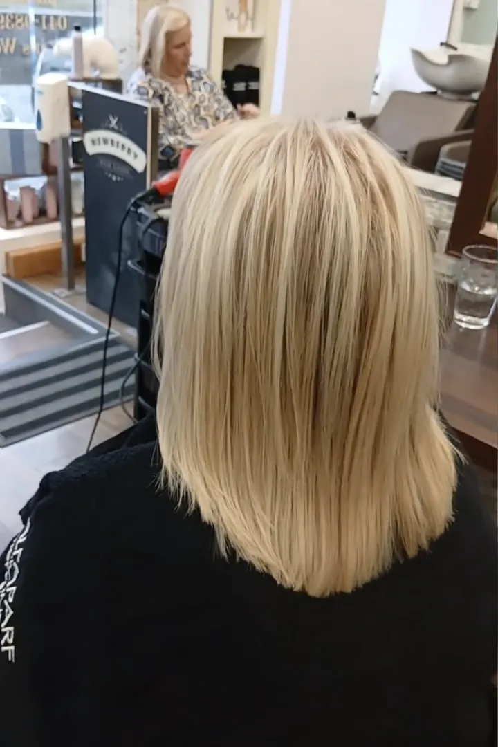 shoulder length blond hair of a woman at a hair salon